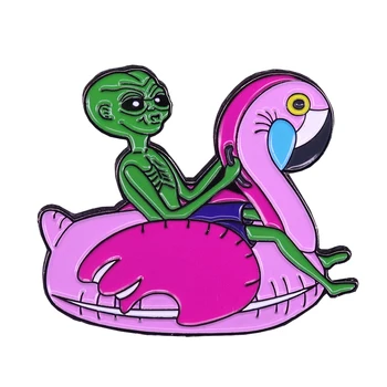 Инопланетянин, сидящий на надувной булавке с изображением фламинго и плавающем значке Paranormal Summertime Collection